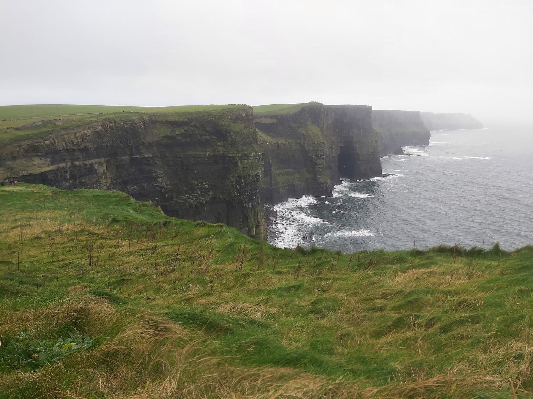 An image of the Cliffs of Moher, shot from the direction looking away from the little castle on the hill